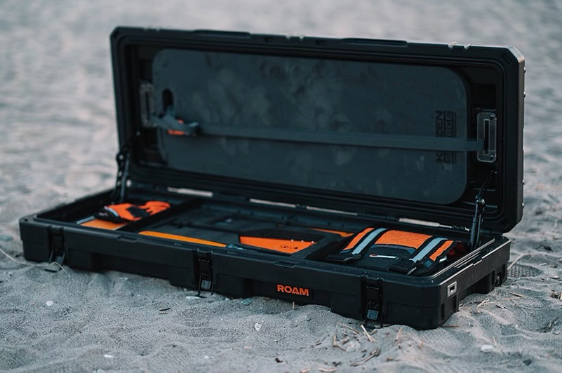 Custom foam insert in ROAM case with orange gear on sand